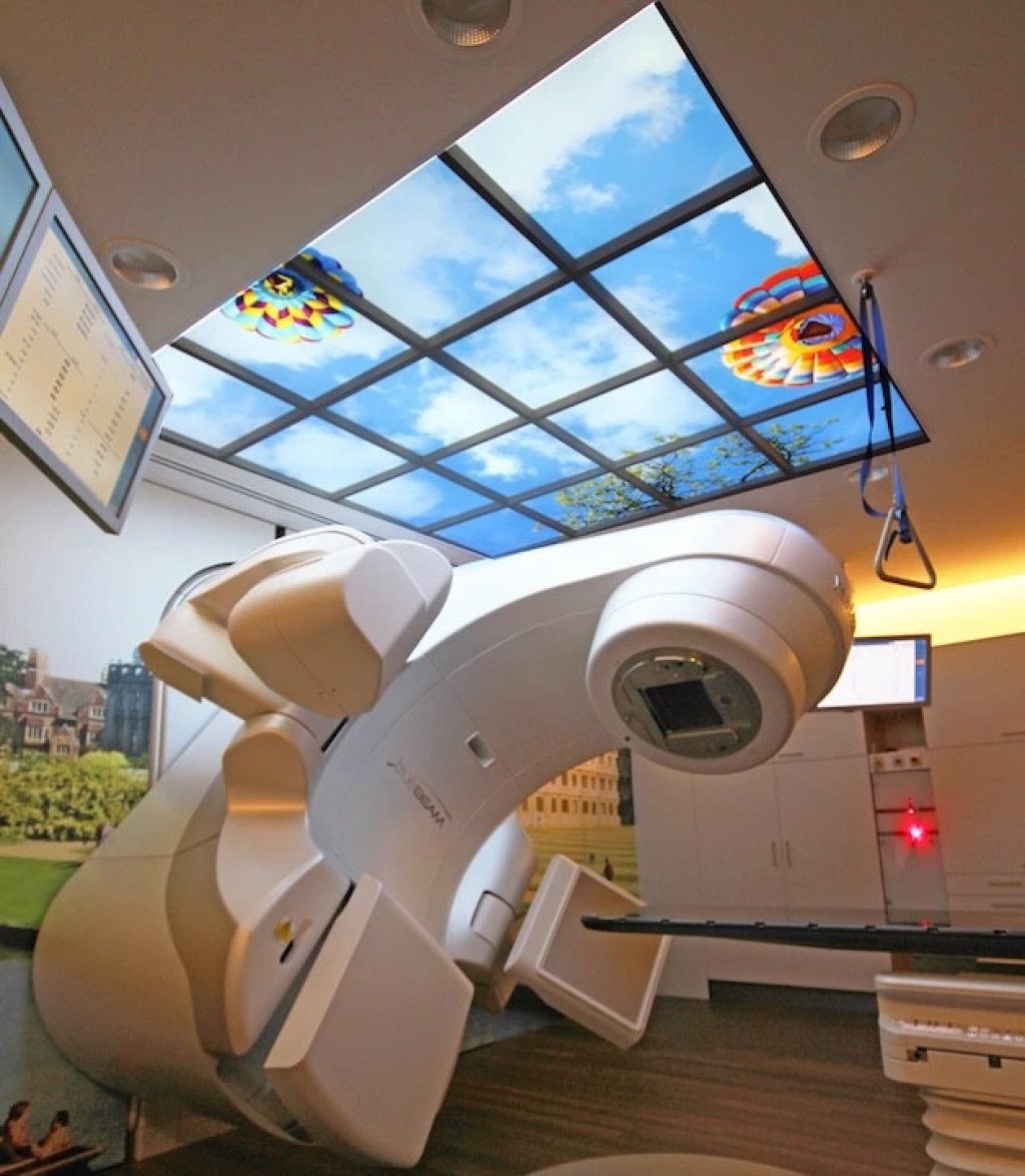 LED plafond in radiotherapieruimte UMCG met wolkendesign voor positieve afleiding tijdens behandeling.