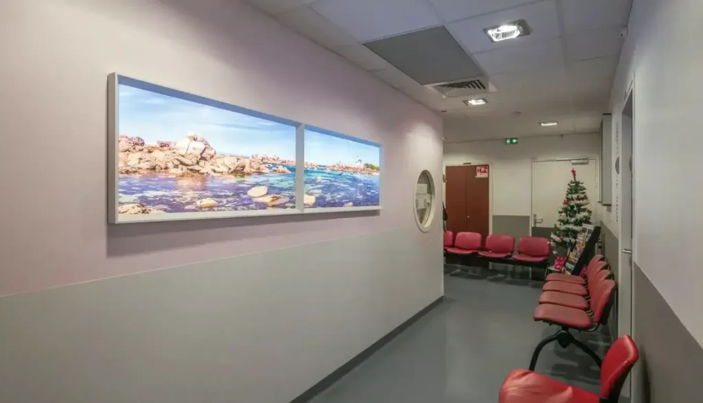 Virtueel raam met uitzicht op een rotskust aan zee in een gang bij de wachtruimte.